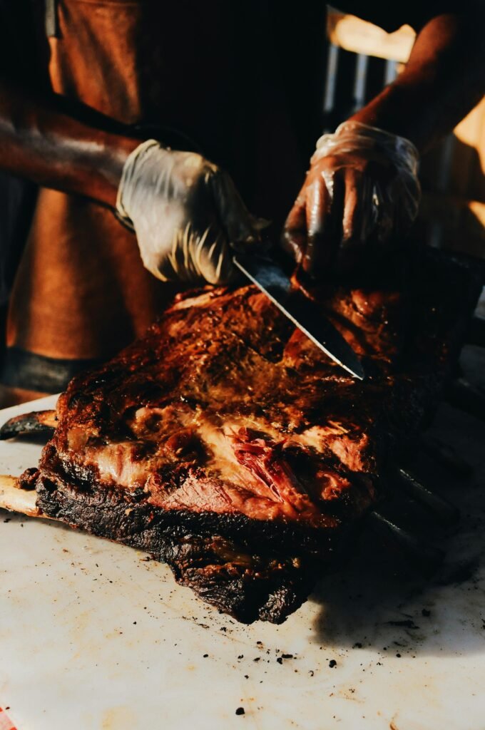 pexels photo 2491272 2491272 1 A skilled chef slices roasted steak on a barbecue grill, showcasing culinary expertise and deliciousness.